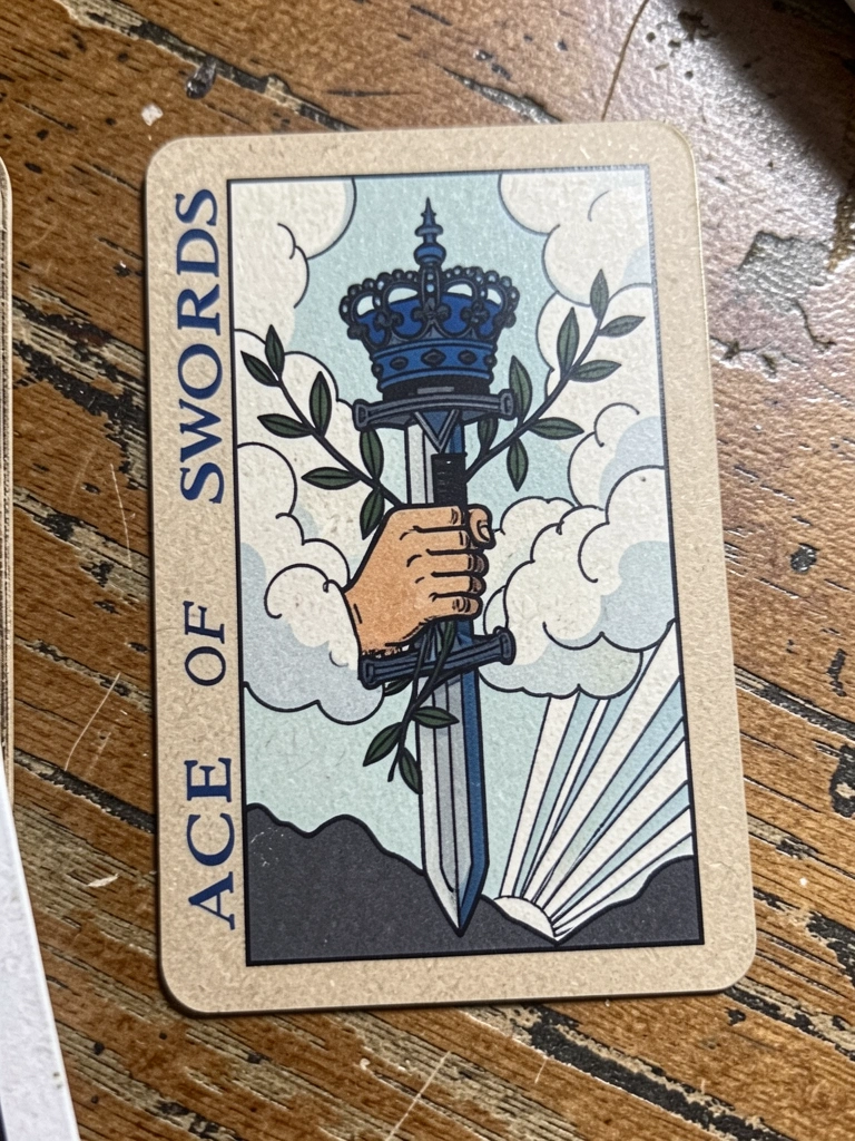 Carta do Ás de Espadas do tarot Rider-Waite, mão segurando espada vertical com coroa e ramos de louro.